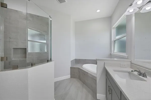 a bathroom with a bathtub sink and mirror