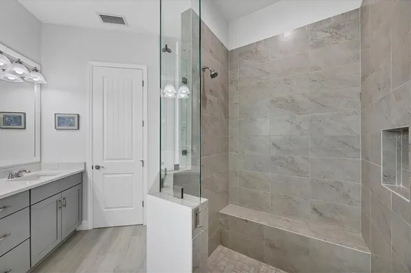 a spacious bathroom with a bathtub shower sink mirror and toilet