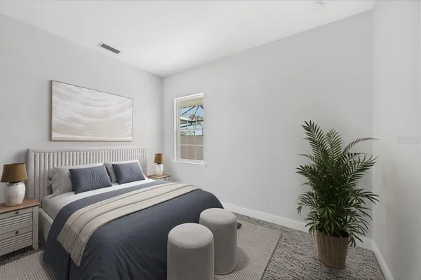 a bedroom with a large bed and a potted plant