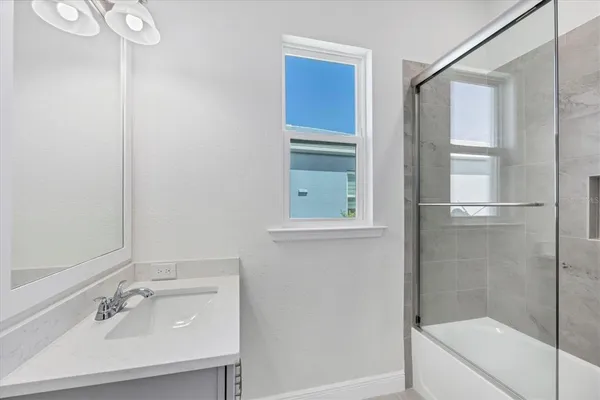 a bathroom with a sink a mirror and a shower