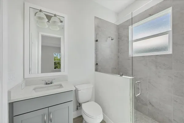 a bathroom with a sink toilet vanity and shower