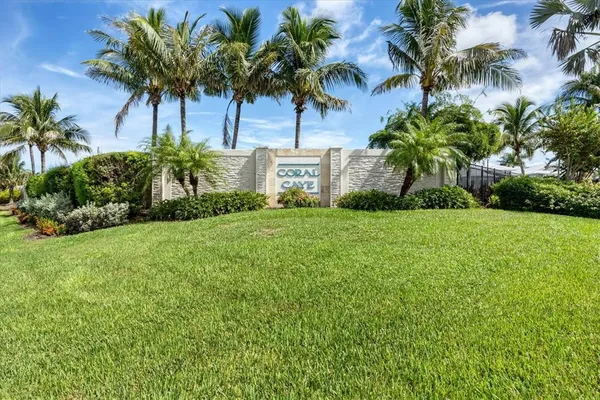 a view of a palm trees sitting in front of a house with a big yard