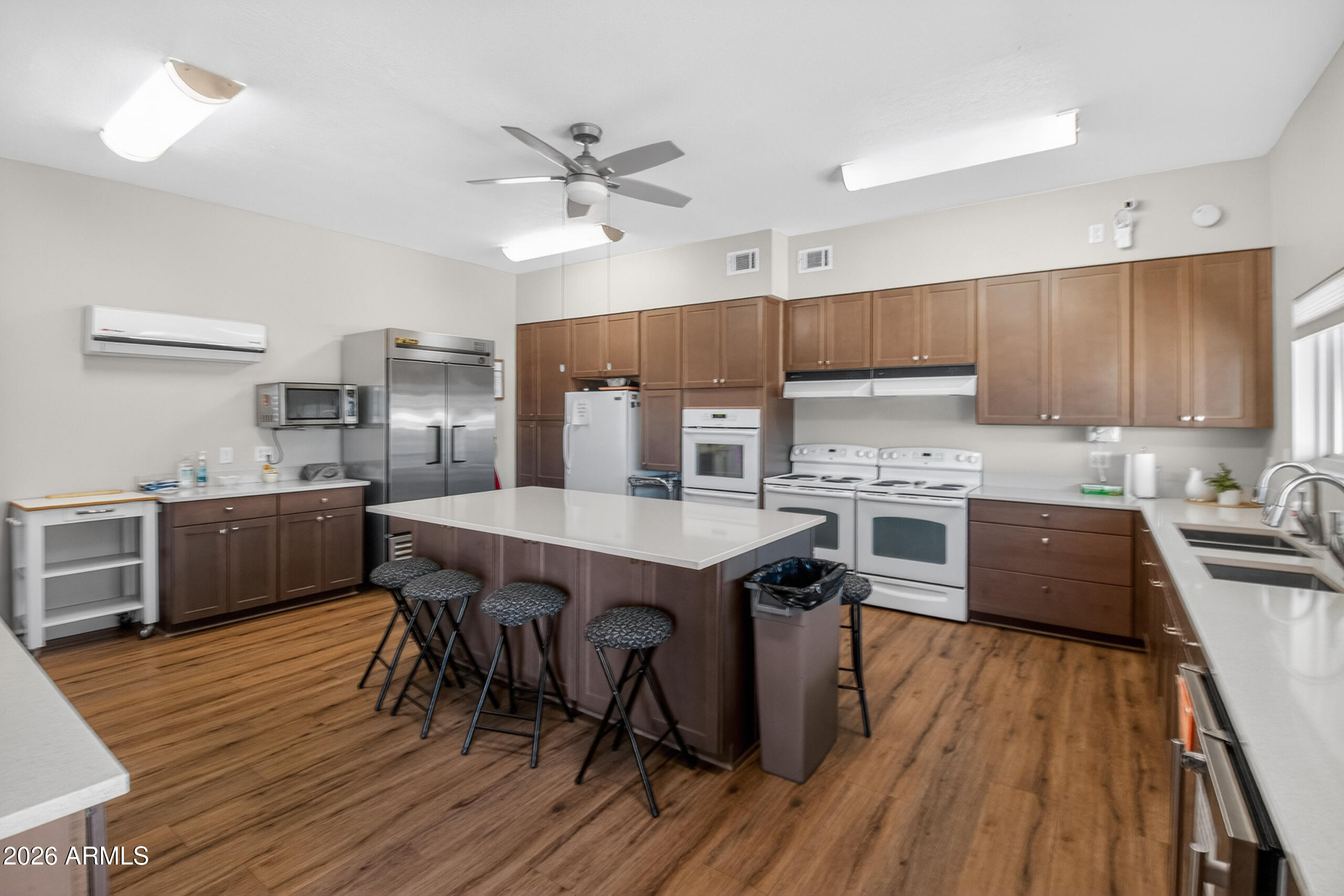 5735 East McDowell Road, Unit 293 Mesa, AZ 85215 - Photo 21 of 40 a kitchen with a table chairs a sink dishwasher stove and cabinets with wooden floor