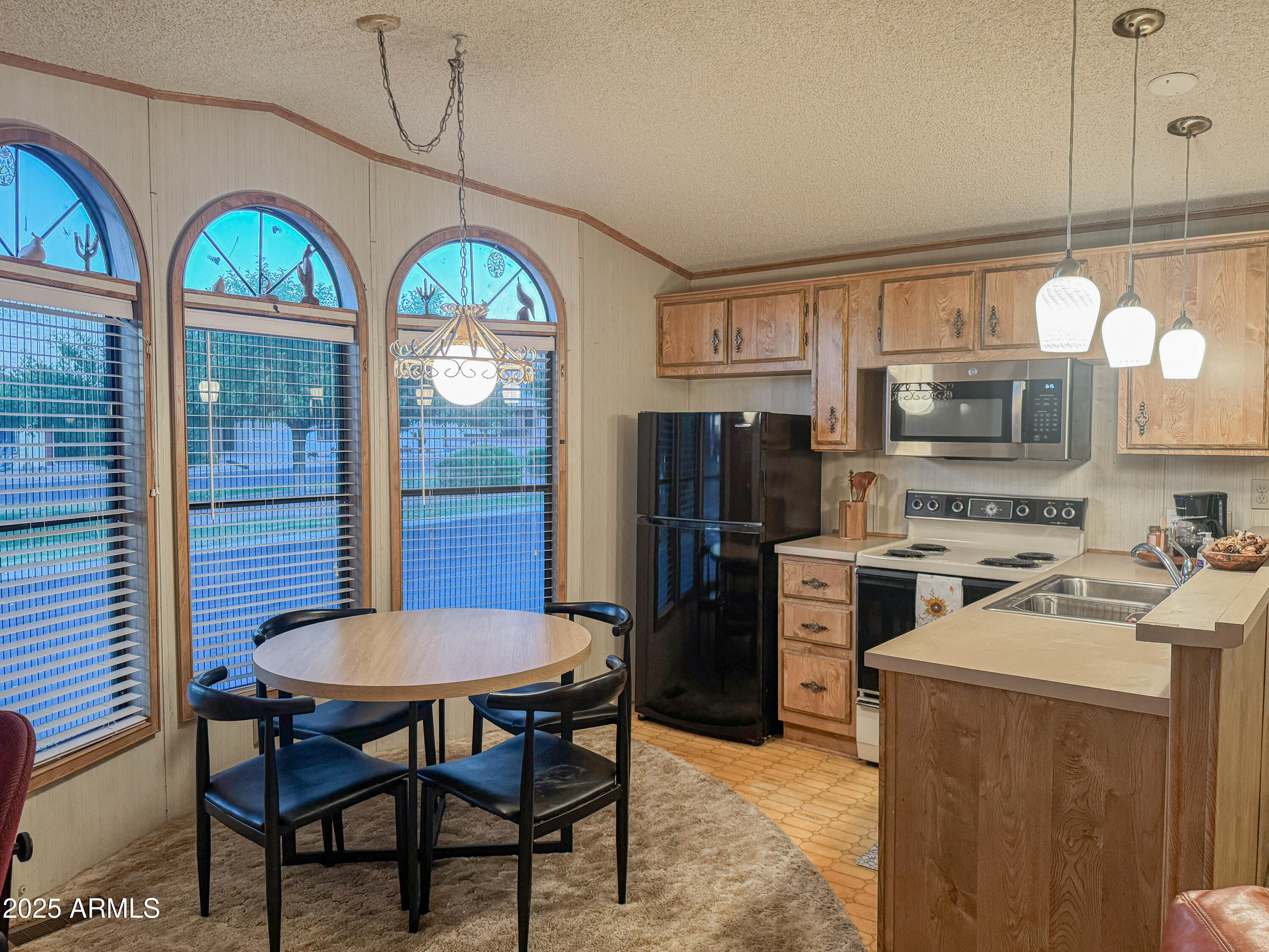 5735 East McDowell Road, Unit 293 Mesa, AZ 85215 - Photo 3 of 40 a kitchen with a table chairs appliances and cabinets