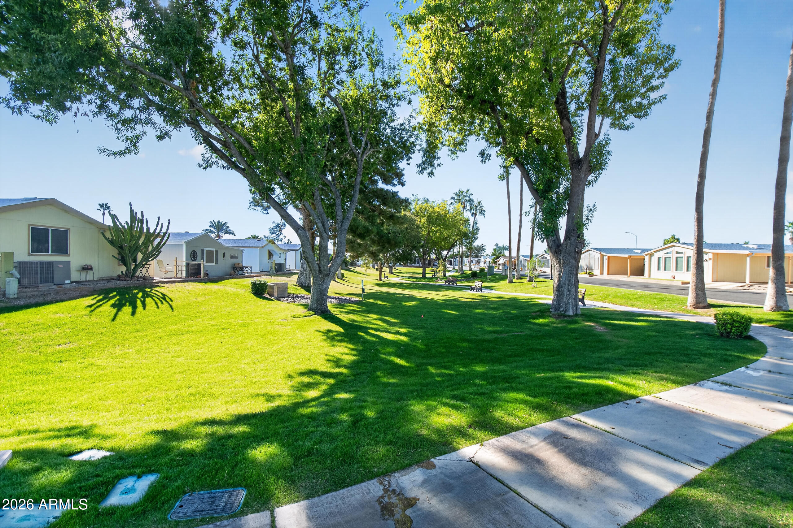 5735 East McDowell Road, Unit 293 Mesa, AZ 85215 - Photo 37 of 40 a view of a swimming pool with a lawn chairs and a big yard
