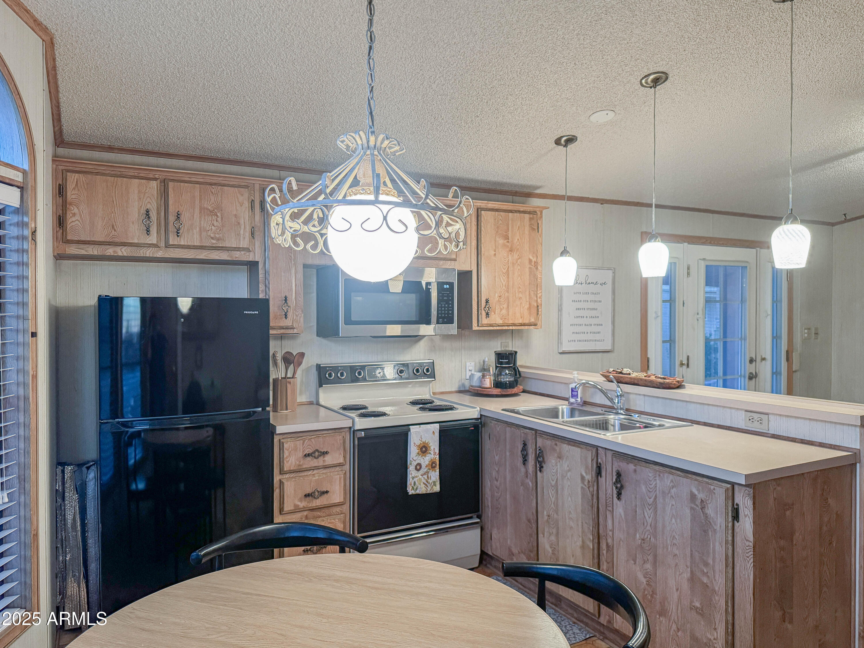 5735 East McDowell Road, Unit 293 Mesa, AZ 85215 - Photo 4 of 40 a kitchen with a sink stainless steel appliances a window and cabinets