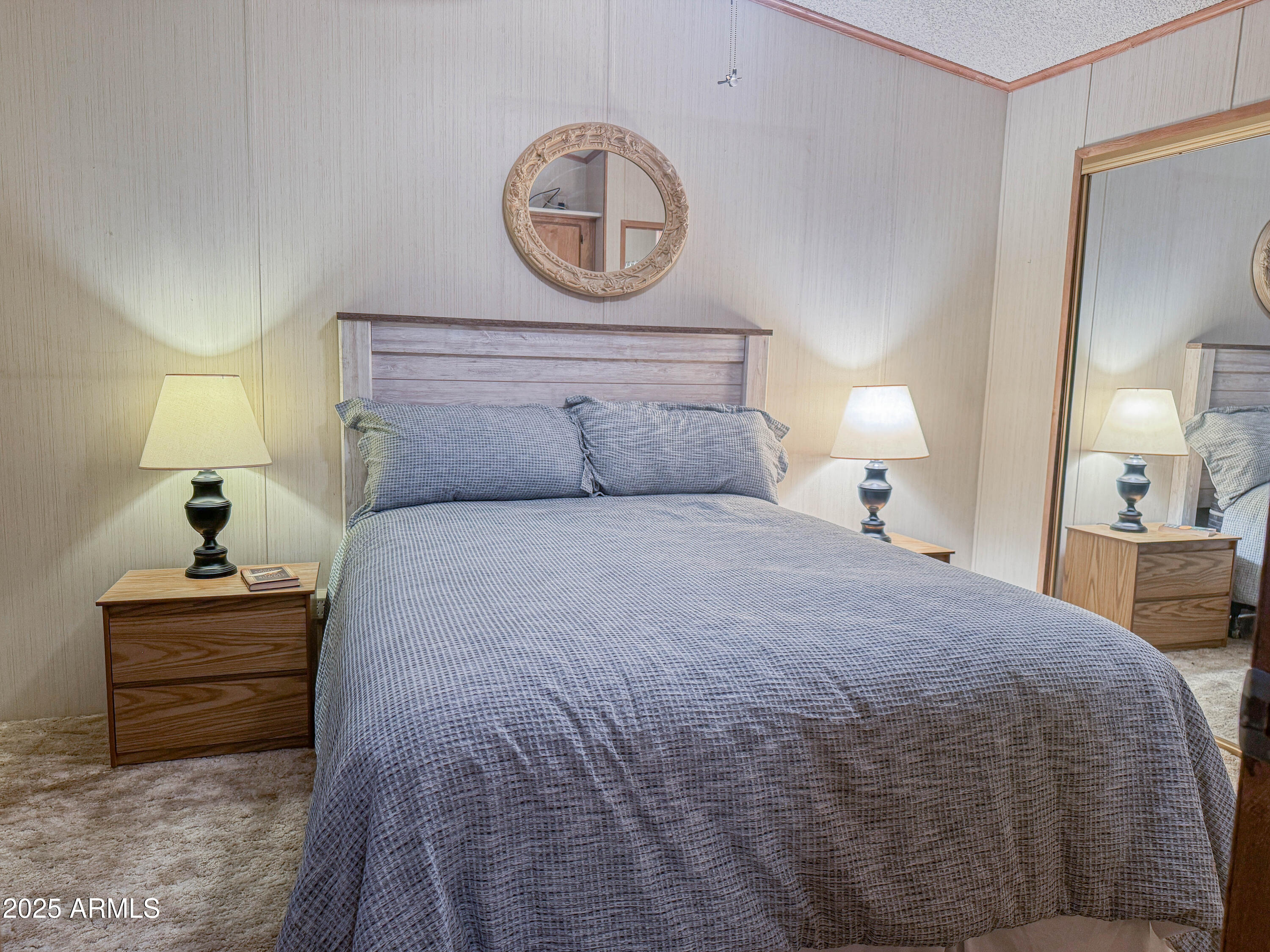 5735 East McDowell Road, Unit 293 Mesa, AZ 85215 - Photo 5 of 40 a bedroom with a bed and a lamp on dresser
