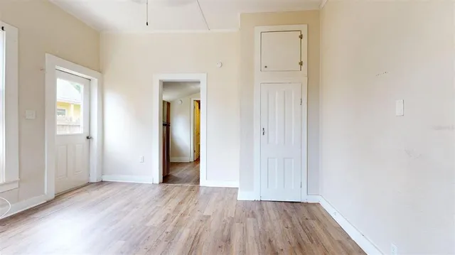 an empty room with wooden floor and closet