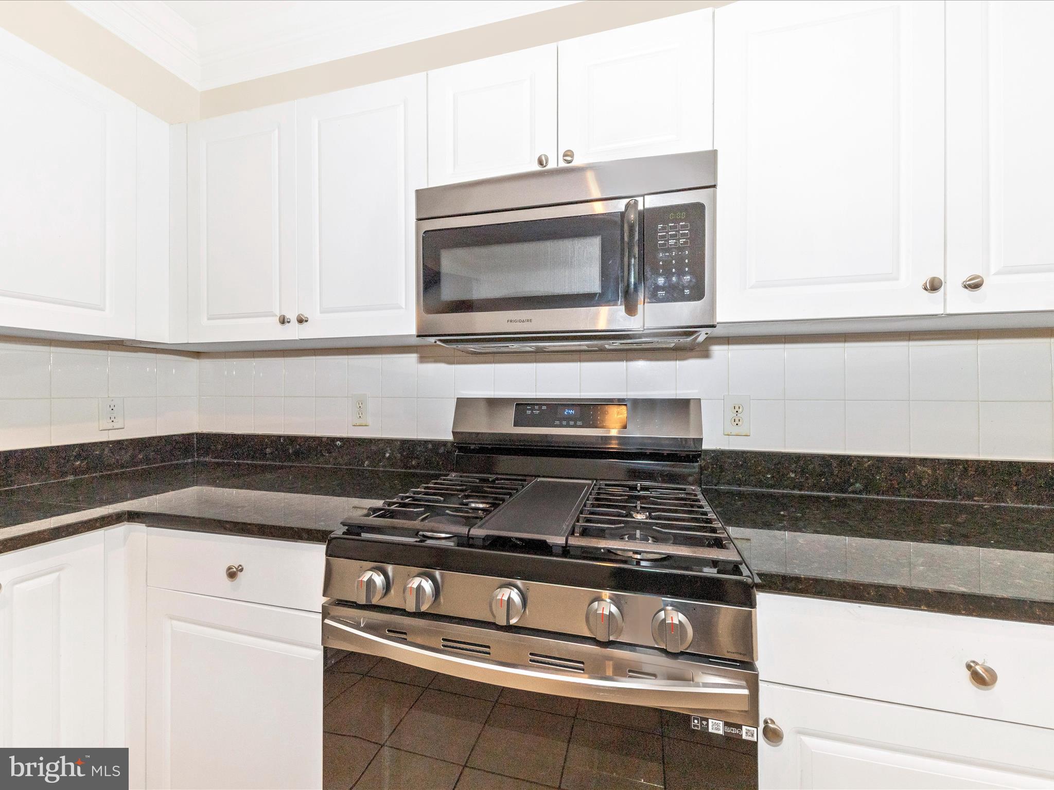 7 Booth Street, Unit 201 Gaithersburg, MD 20878 - Photo 14 of 67 a stove top oven sitting inside of a kitchen