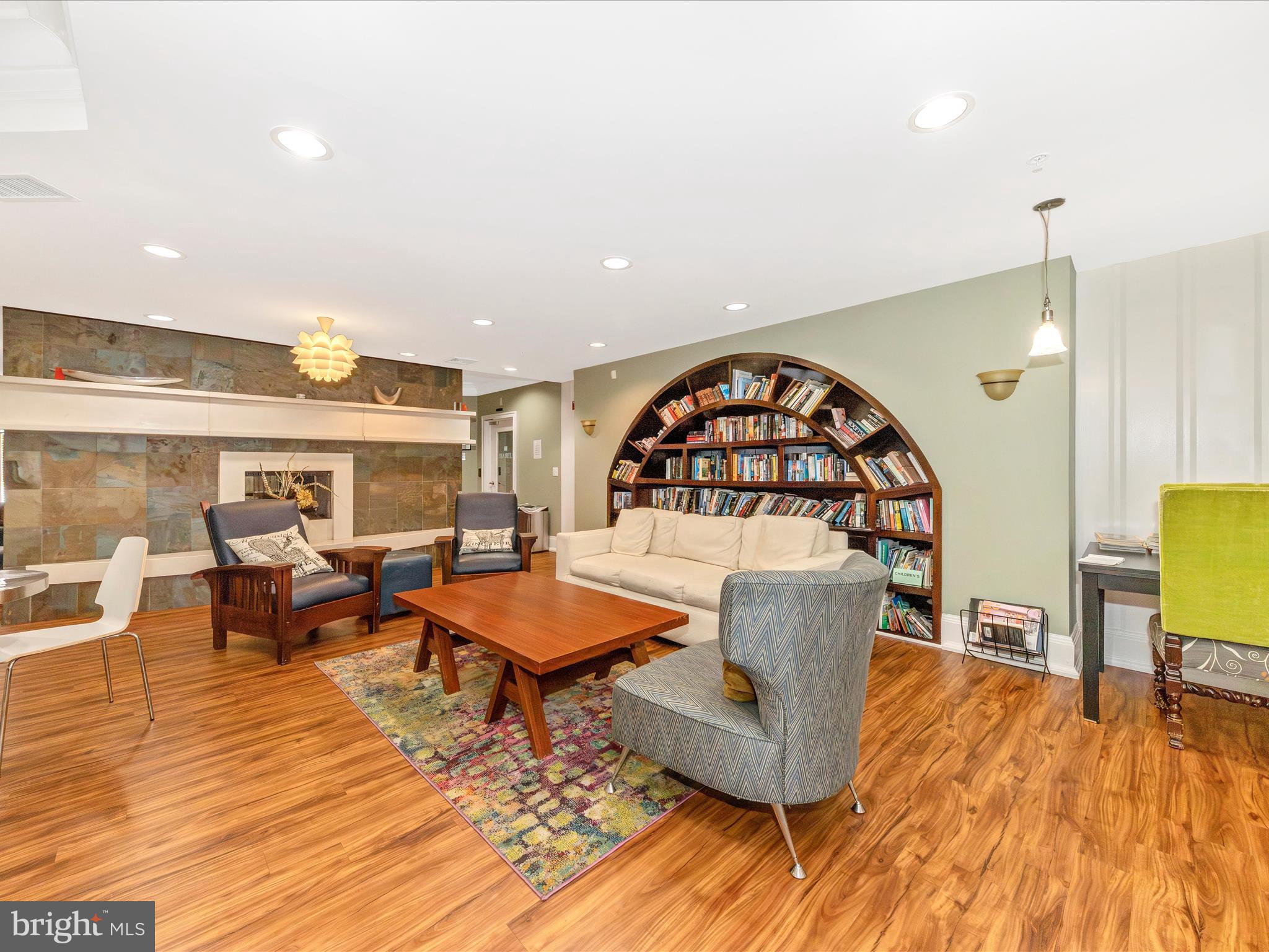 7 Booth Street, Unit 201 Gaithersburg, MD 20878 - Photo 50 of 67 a living room with couches and a dining table with wooden floor