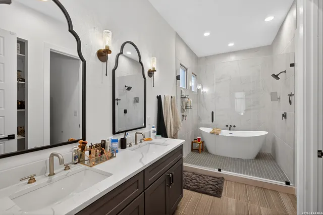 a bathroom with a double vanity sink mirror and bathtub