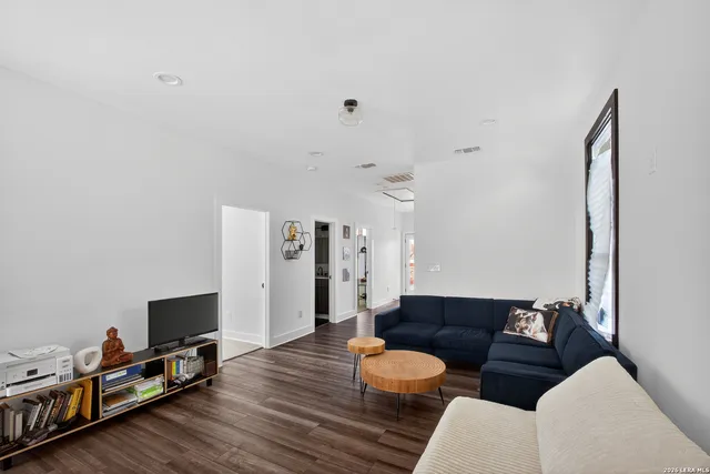 a living room with furniture and a wooden floor