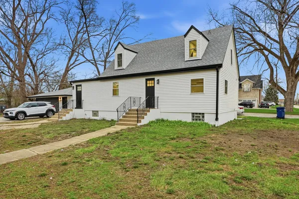 a white house that has tree in front of it