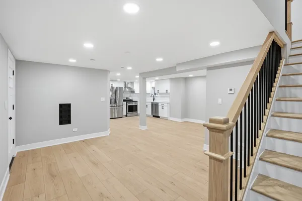 a view of a hallway with wooden floor and kitchen
