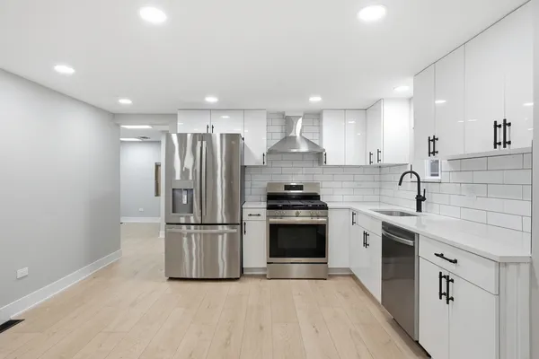 a kitchen with granite countertop stainless steel appliances a refrigerator sink and microwave