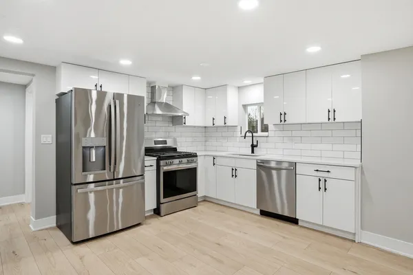 a kitchen with stainless steel appliances granite countertop a sink stove and cabinets
