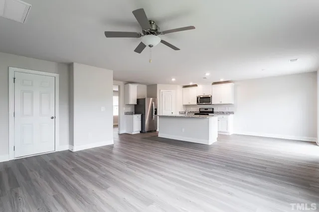 a view of kitchen with granite countertop cabinets and refrigerator