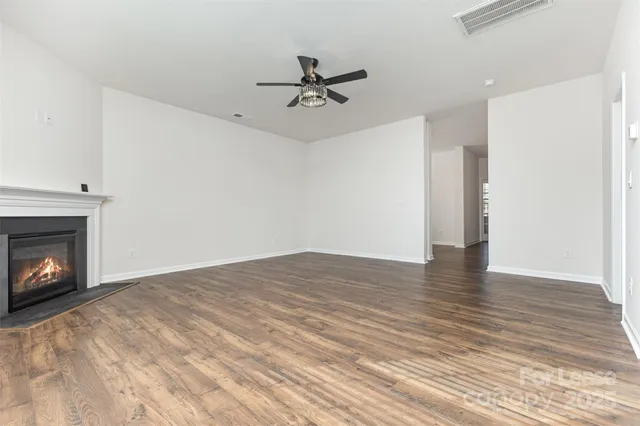 a view of empty room with wooden floor and fireplace