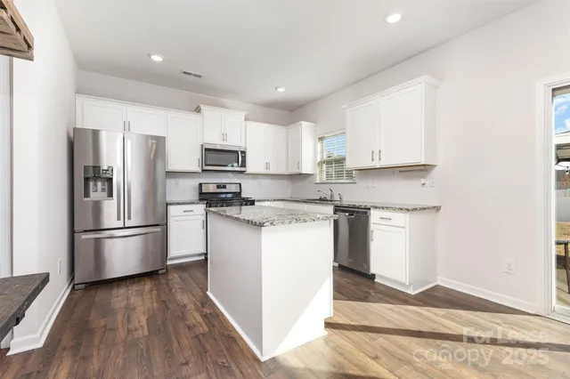 a kitchen with stainless steel appliances granite countertop a refrigerator sink and microwave