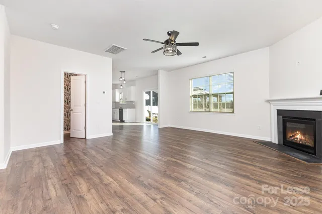 a view of empty room with a fireplace and wooden floor