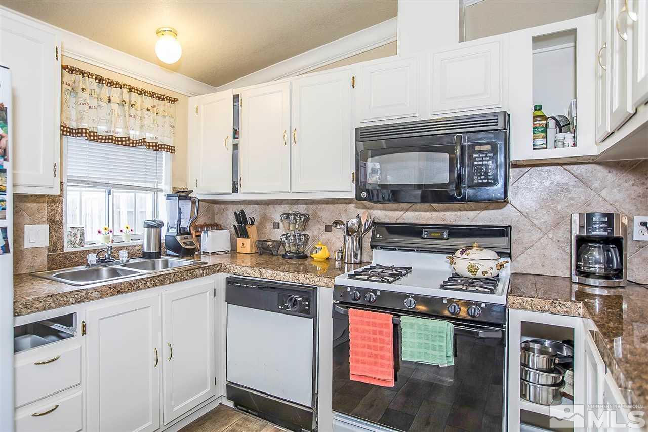 2735 Snapdragon Way Reno, NV 89512 - Photo 4 of 18 a kitchen with stainless steel appliances granite countertop a stove top oven a sink dishwasher and cabinets with wooden floor