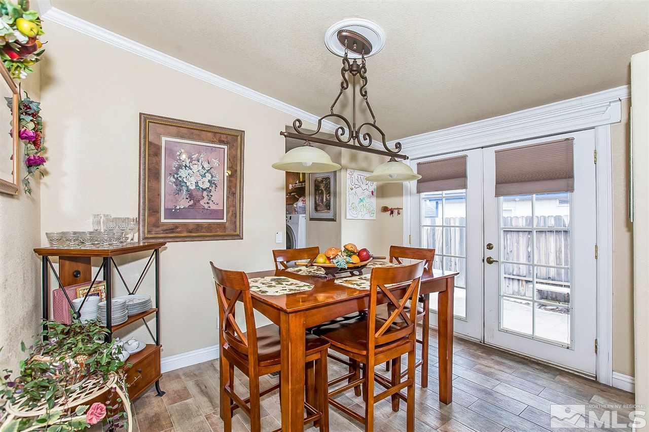 2735 Snapdragon Way Reno, NV 89512 - Photo 7 of 18 a dining room with furniture a chandelier and wooden floor