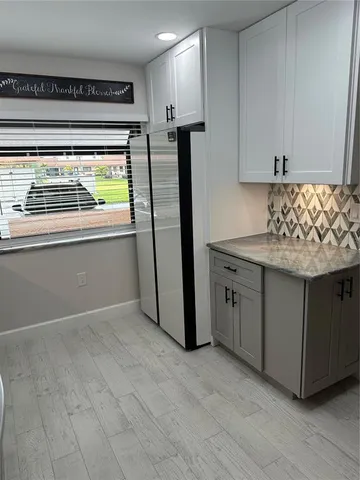 a kitchen with stainless steel appliances granite countertop a refrigerator and a sink