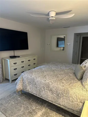 a bedroom with a bed and flat tv screen