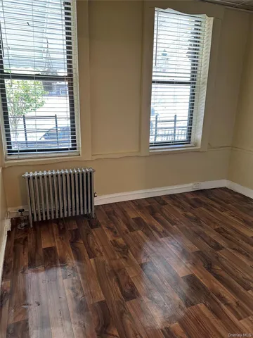 a view of a room with wooden floor and a window
