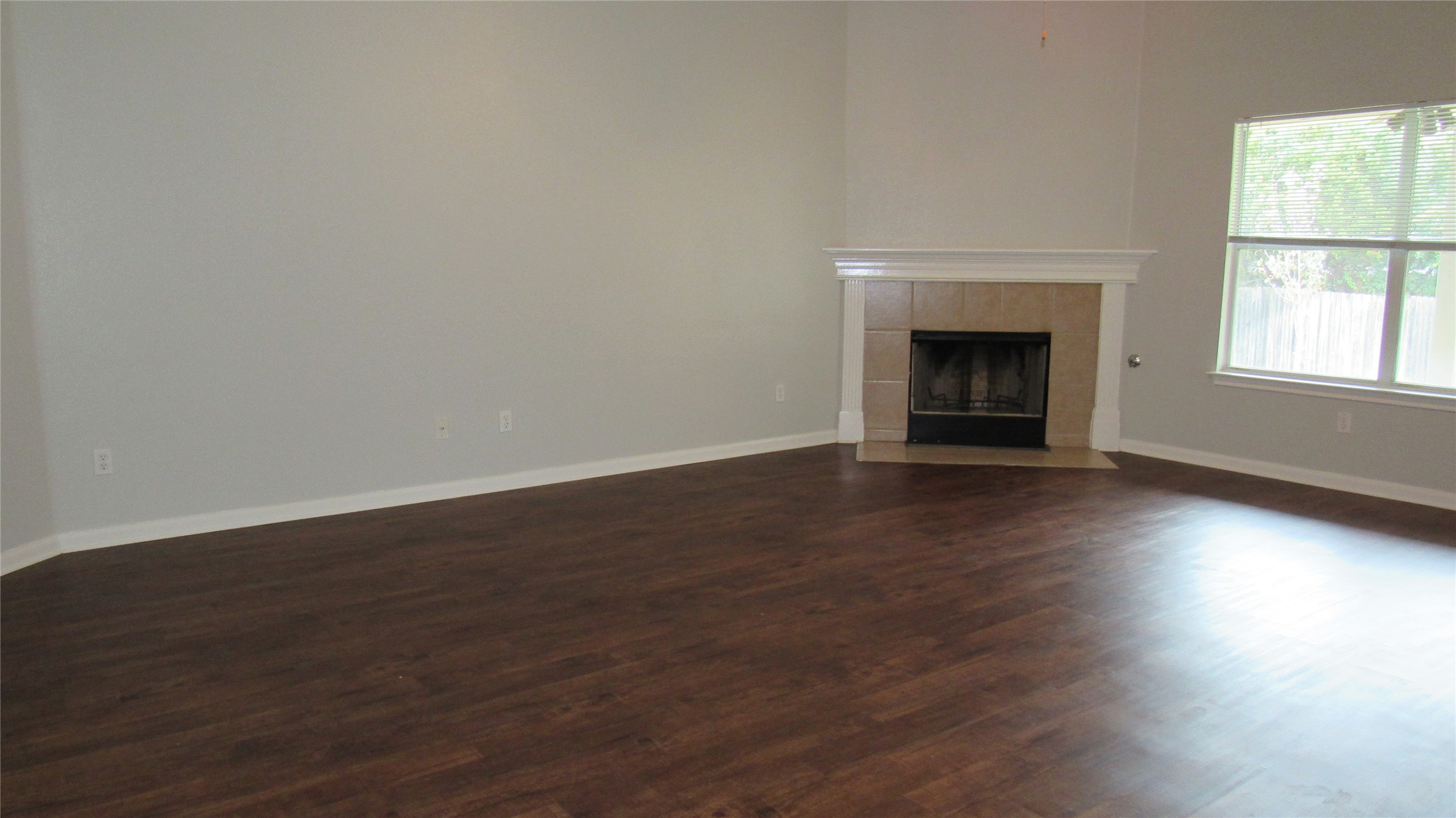 1510 Ridgewood Drive Leander, TX 78641 - Photo 7 of 19 an empty room with wooden floor fire place and windows