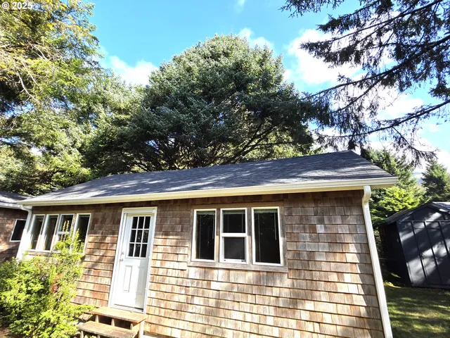 a front view of a house with a tree