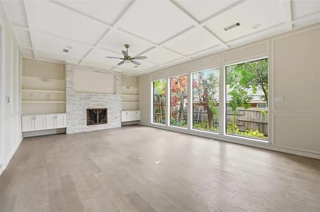 a view of an empty room with a fireplace and a window