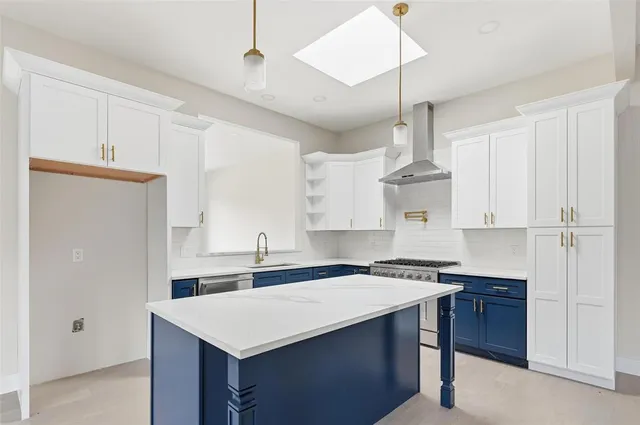 a kitchen with a sink a stove a refrigerator and white cabinets