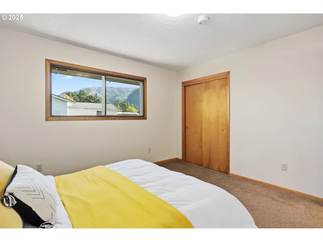 a bedroom with a bed and a painting on the wall