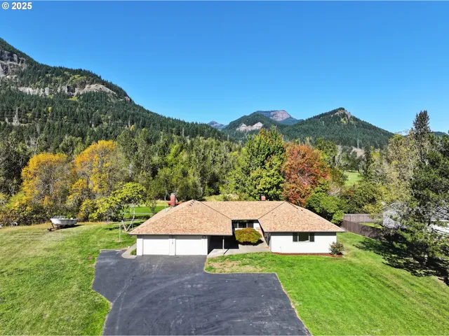 a view of a house with a yard and mountain