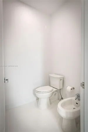 a white toilet sitting next to a bathroom sink