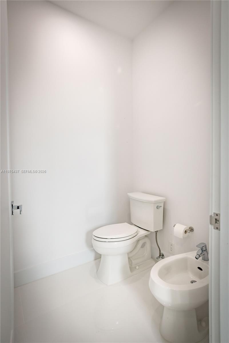 3107 Southwest 26th Street, Unit 3107 Miami, FL 33133 - Photo 14 of 26 a white toilet sitting next to a bathroom sink