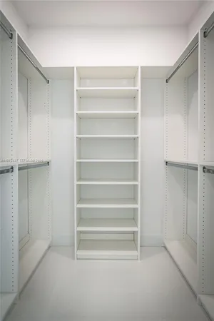 a view of walk in closet with empty racks