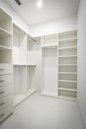 a view of walk in closet with empty racks
