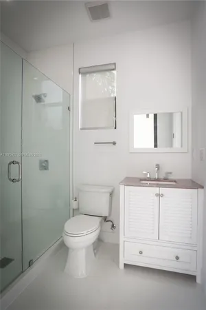 a bathroom with a granite countertop toilet sink and mirror