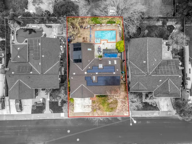 an aerial view of a house with a garden and parking space