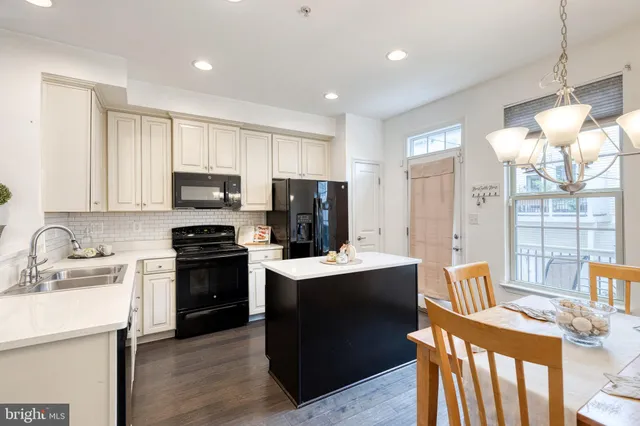a kitchen with kitchen island granite countertop a sink appliances and cabinets