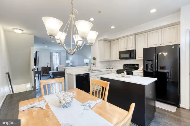 a kitchen with sink a refrigerator a stove a microwave oven a dining table and chairs