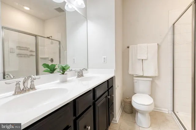 a bathroom with a granite countertop sink toilet a large mirror and shower