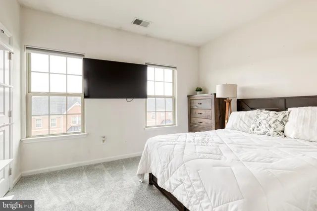 a bedroom with a large bed and a flat tv screen on a dresser