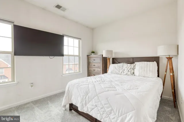 a bedroom with a large bed and a flat tv screen on dresser