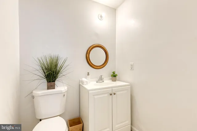 a bathroom with a toilet a sink and a mirror