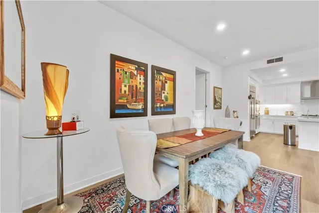 a living room with furniture a table and kitchen view