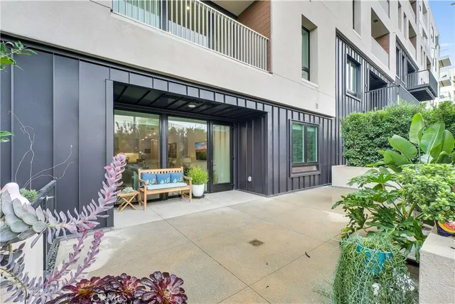a view of a patio with table and chairs potted plants with floor to ceiling window and garden