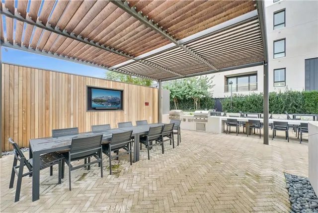 a outdoor space with lots of tables a large window and chairs